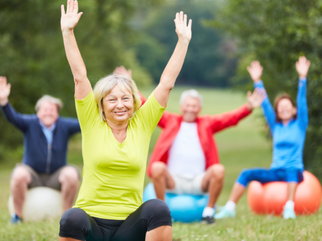 A group of older people exercising in a park