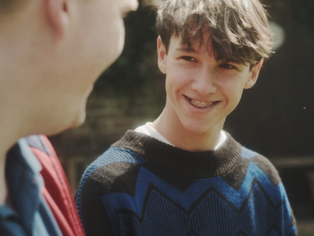 A photo of a teenager in a blue jumper with braces