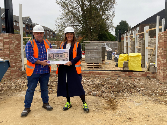 The image shows Council Leader Bella Sankey and Councillor Paul Nann, donning hard hats and hi-vis vests while holding the Housing Design Award at the site of the emerging Brickfields development.