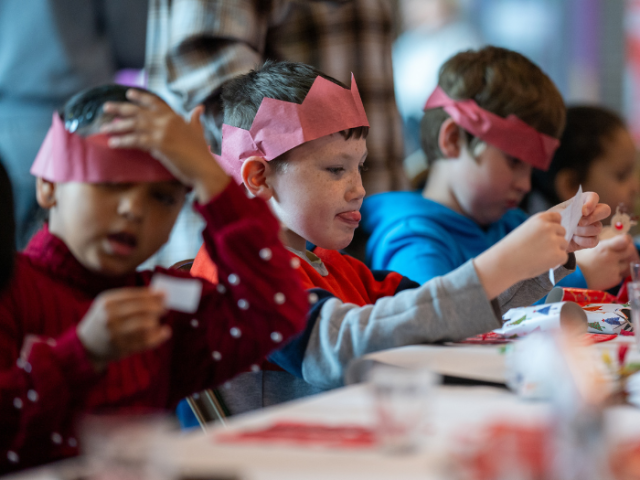 A group of children wearing Christmas hats at a HAF session