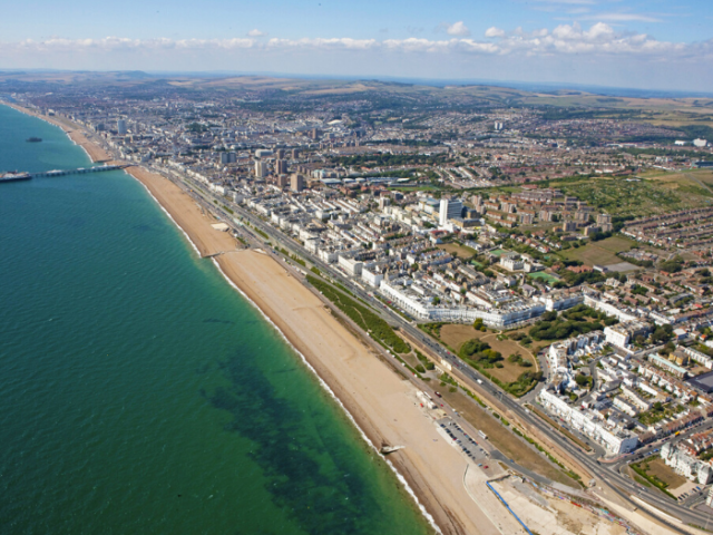 an ariel shot of a city with the sea, beach and buildings
