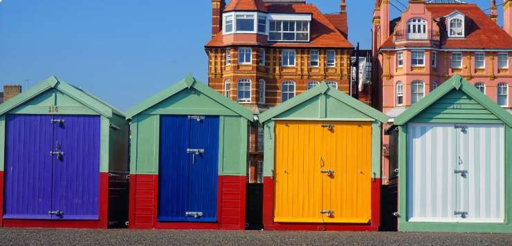 Four colourful, painted beach huts