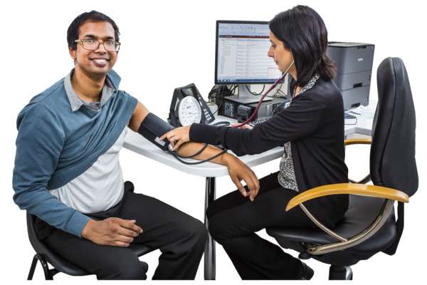 Patient getting blood pressure taken by care professional.