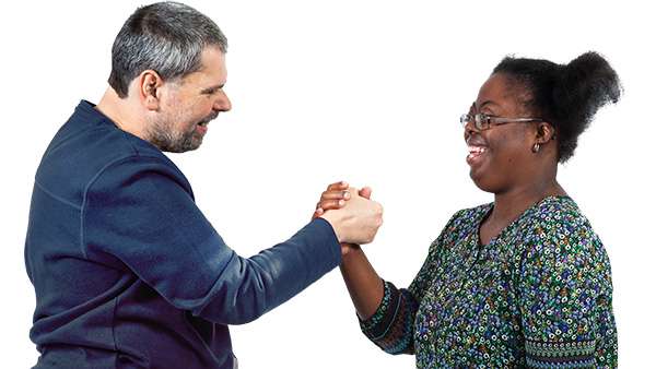 Two friends smiling and shaking hands.