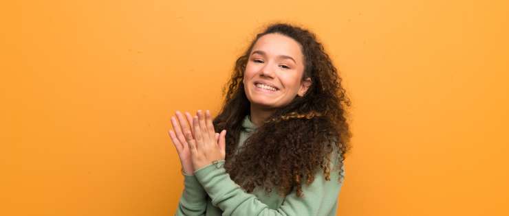 Teenager smiling and clapping their hands