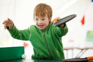 Photograph of a child happily playing table tennis