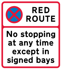 A white sign outlined in red. Black text reads 'Red Route. No stopping at any time except in signed bays.