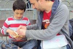 Photograph of a man helping a child