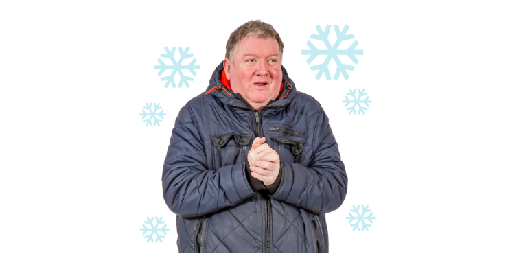 Man in coat rubbing hands together, surrounded by large blue snowflakes.