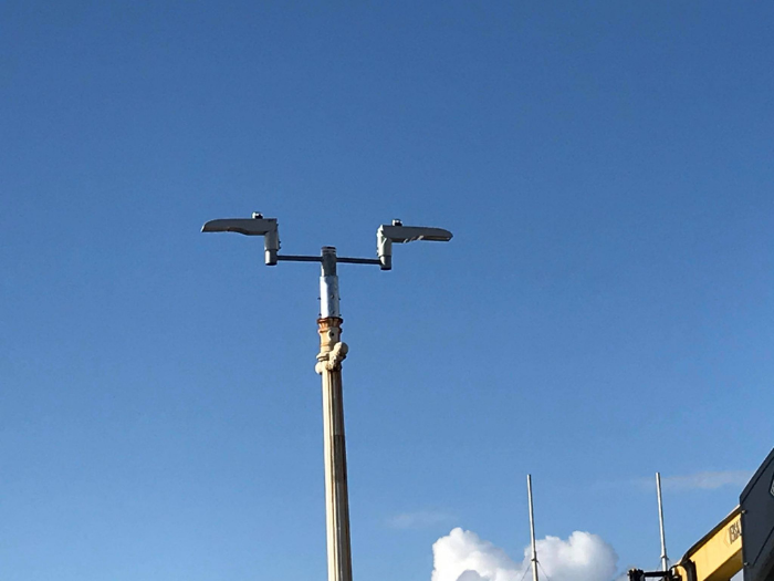 "A streetlight with two lamps pointing in opposite directions"